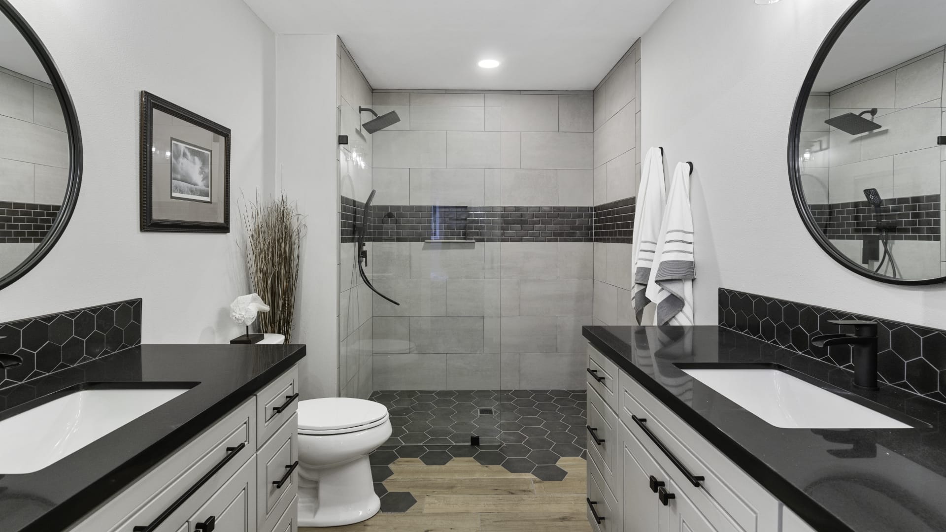 remodeled bathroom with dark tile and countertops