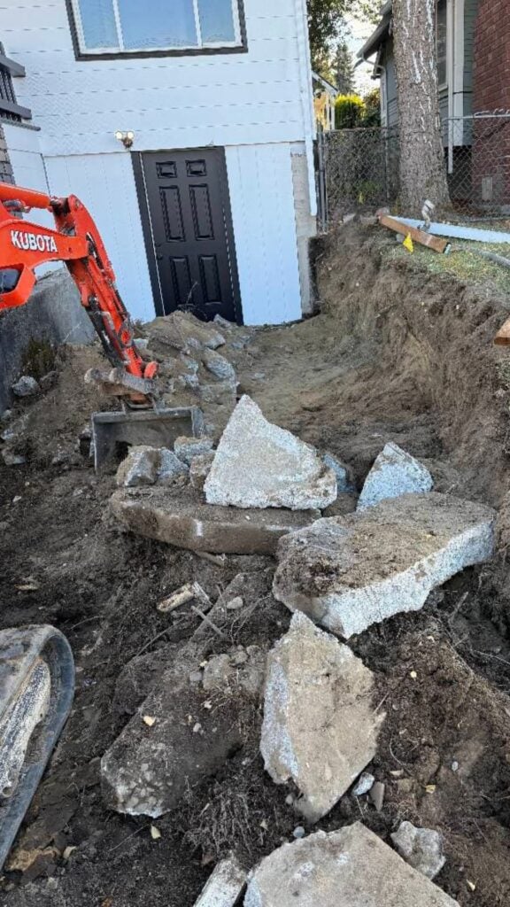 excavating machine removing a concrete driveway