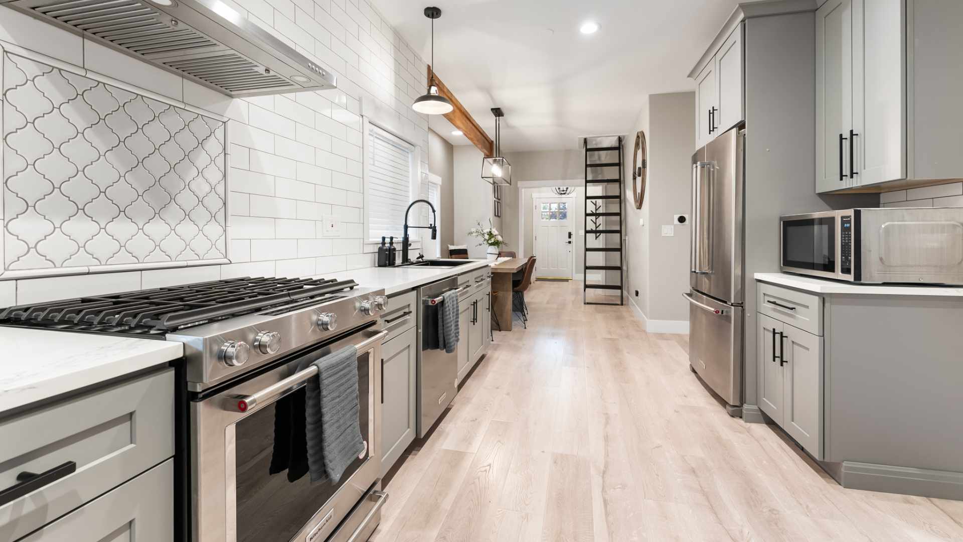 a remodeled kitchen with dining room and loft stairs