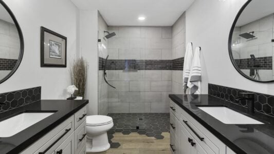 remodeled bathroom with dark tile and countertops
