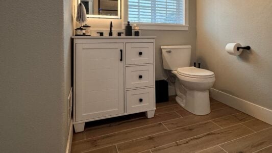 a bathroom with new cabinets and toilet