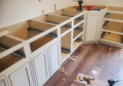 kitchen cabinets being installed with drawer hardware and shims