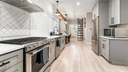 a remodeled kitchen with dining room and loft stairs